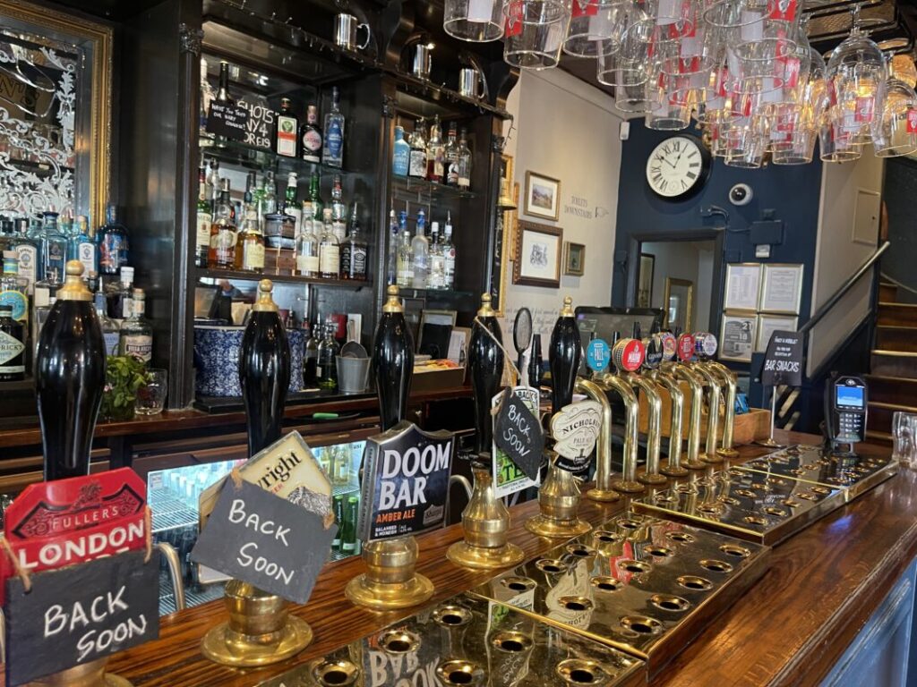 ロンドンのパブの店内、ビールのサーバーが並ぶカウンター